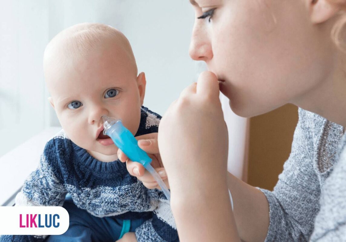 Mamãe utilizando o aspirador nasal no seu bebê