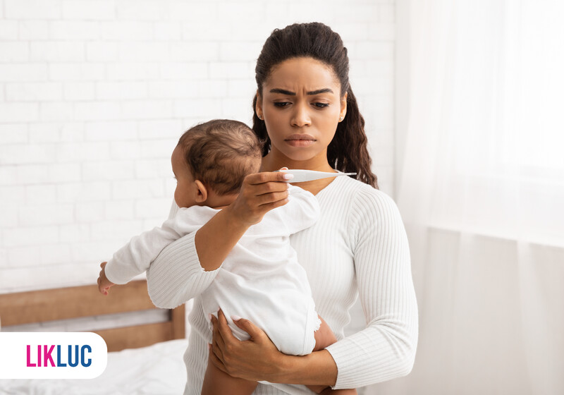 Mãe preocupada medindo febre em bebê.