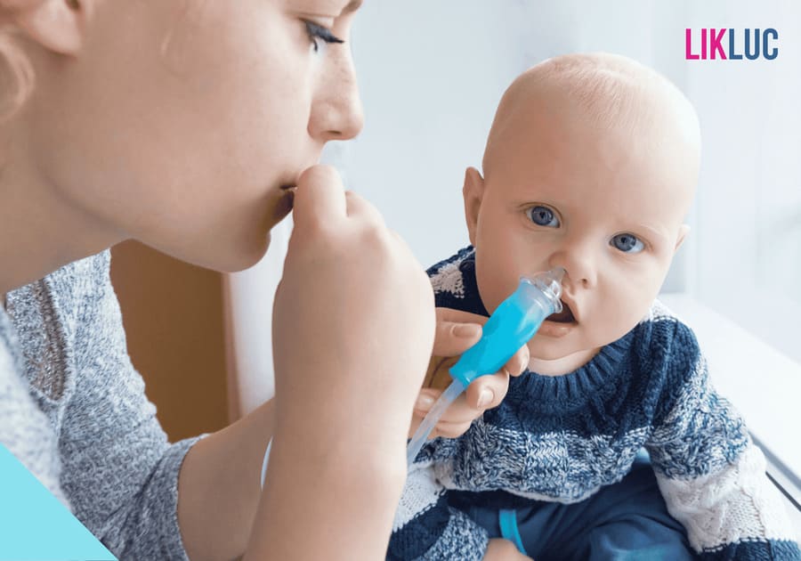 mãe utilizando aspirador nasal no bebe