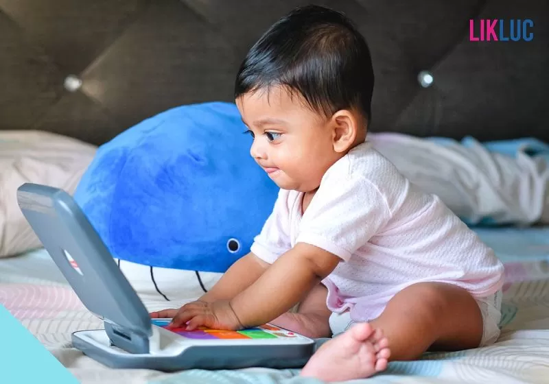 Bebê mexendo no computador de brinquedo