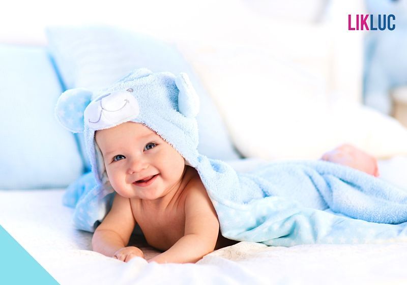 bebe-de-roupao-azul-deitado-sorrindo-apos-banho