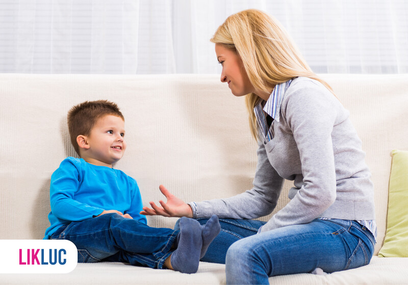 Mãe e filho conversando em um sofá