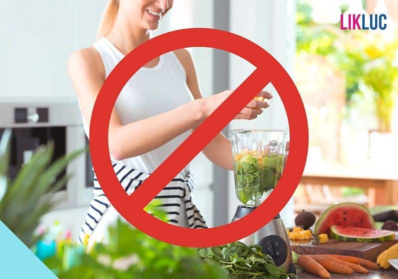 Mulher batendo frutas no liquidificador com um sinal de proibido na frente