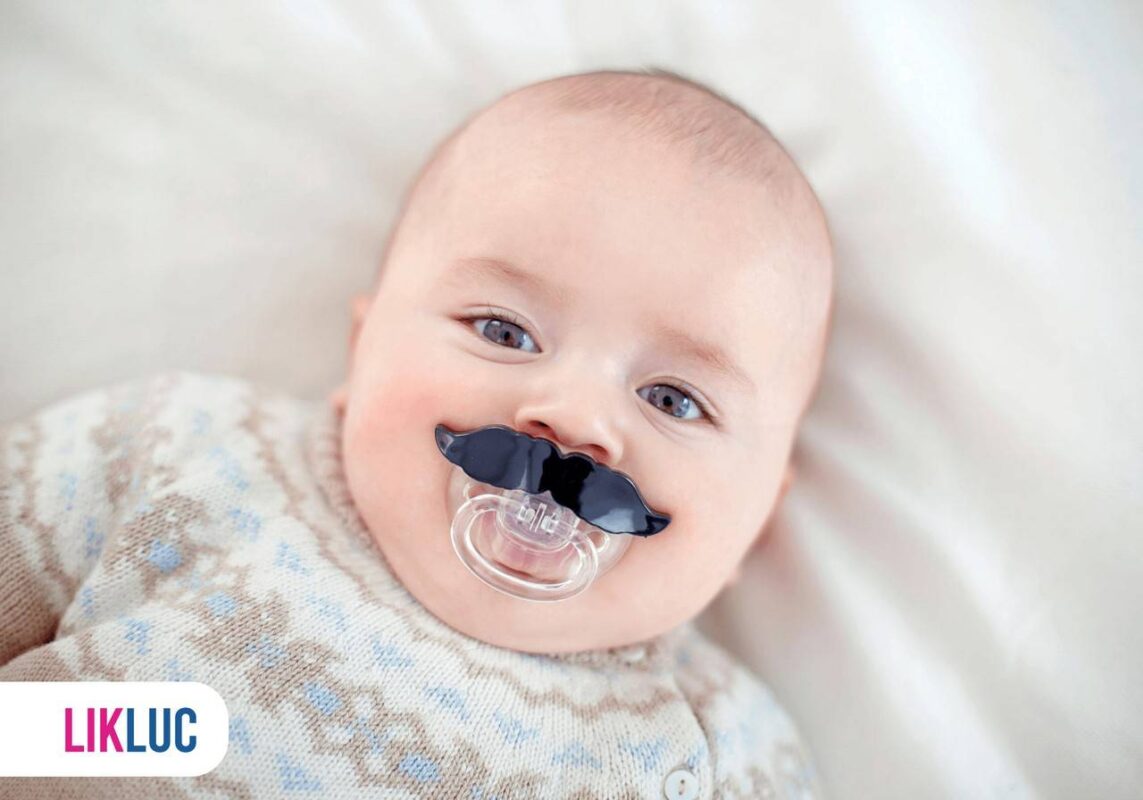 Bebê deitado e com chupeta com formato de bigode