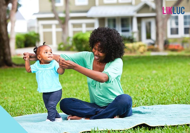 Bebê e mamãe brincando na frente de sua casa no jardim