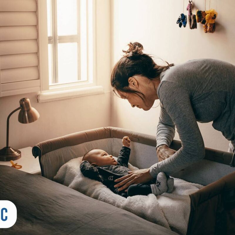 Mãe fazendo o bebê dormir no berço