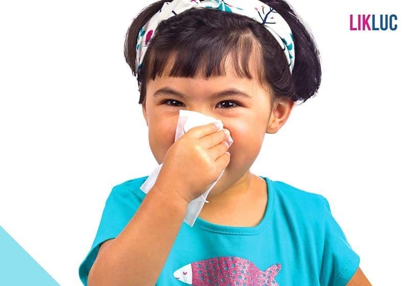 menina assoando o nariz após espirro
