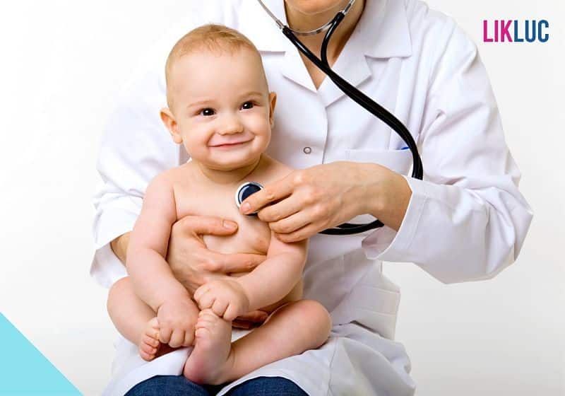 bebê sorrindo e sendo testado por médico