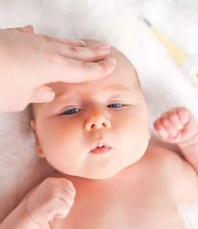 mão na testa do bebê medindo a febre