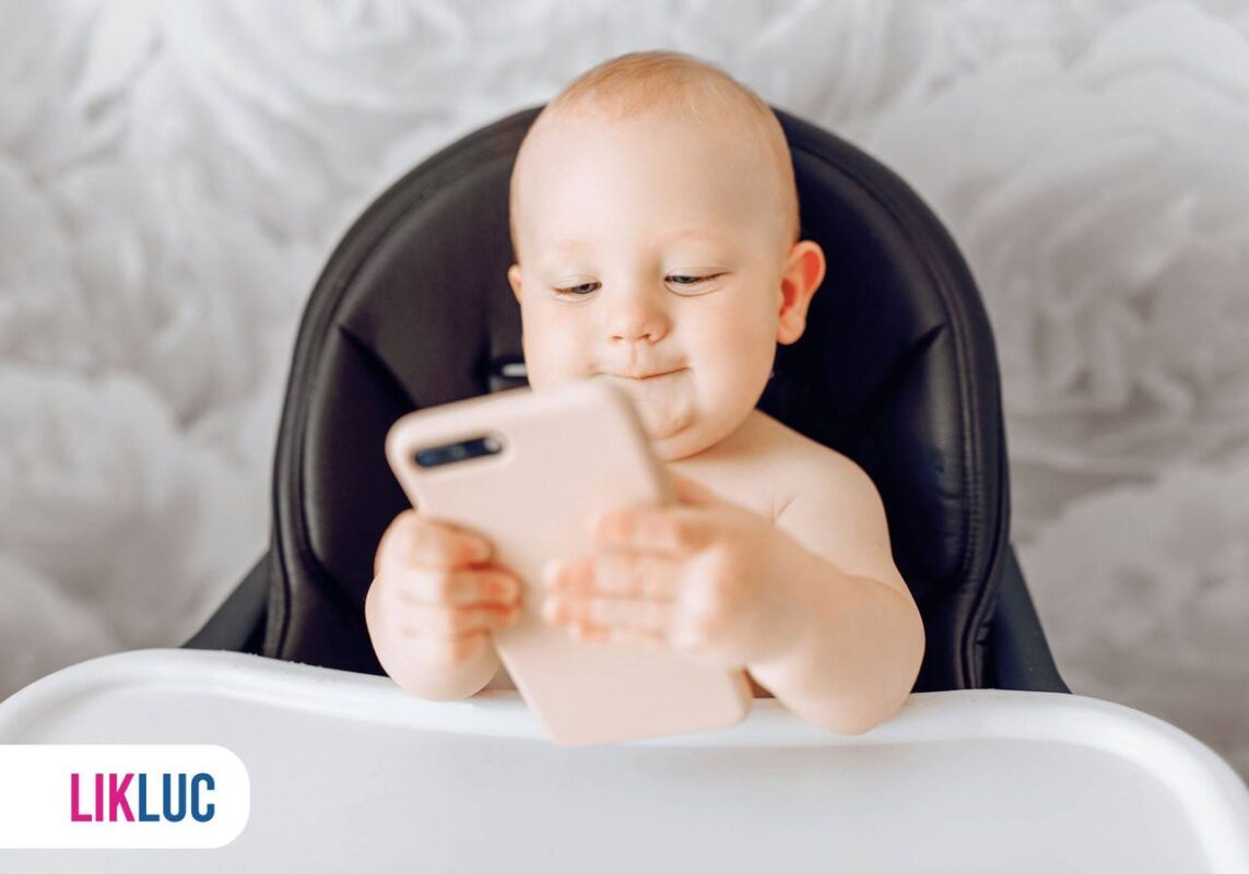 Bebê sentado e segurando celular