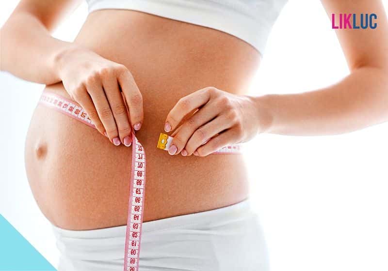 Mulher medindo barriga de gravidez