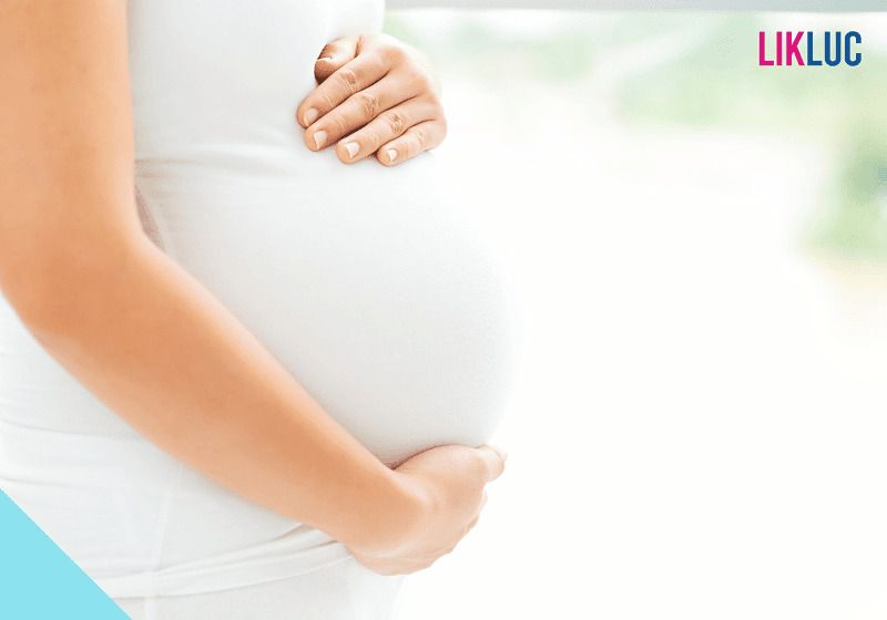 gestante vestida de branco segurando barriga