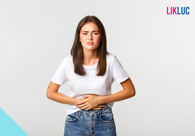 Jovem com dor abdominal e expressão preocupada.