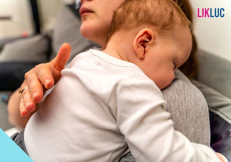 Mãe aconchegando o bebê enquanto dorme