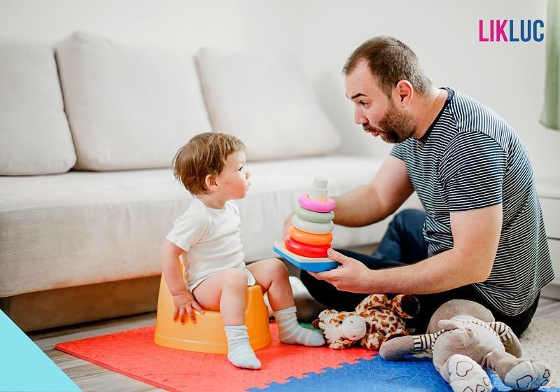 pai brincando com bebê que está sentado no troninho