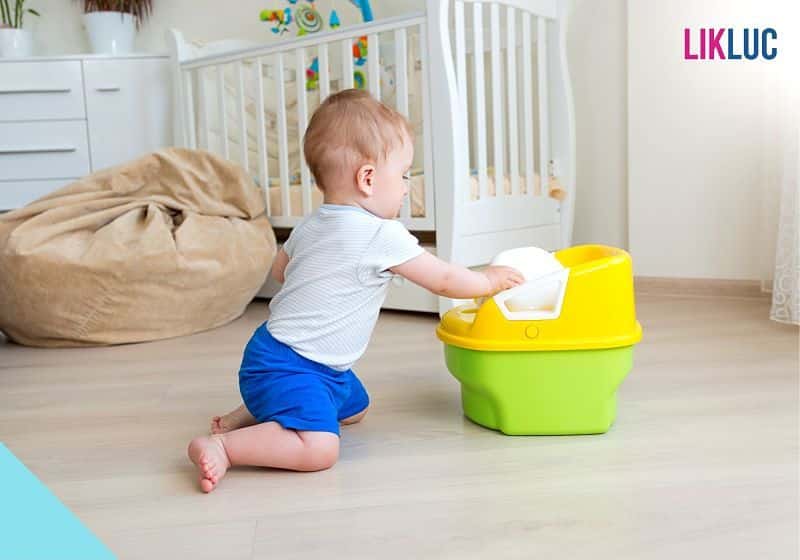 bebe com penico no quarto opt bebe ajoelhado mexendo em penico infantil e puff e berço ao fundo