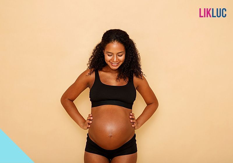 sintomas no terceiro trimestre gestante de frente olhando para a barriga opt