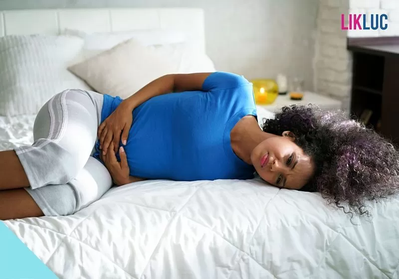 mulher deitada de lado com colica