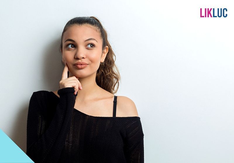 mulher de preto de frente com mão na bochecha pensando
