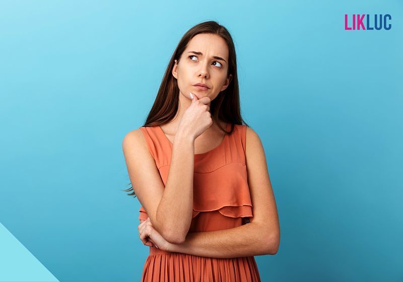 gravida e menstruar mulher pensativa fundo azul opt