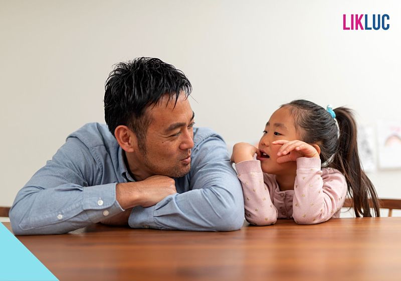 Pai e filha se divertindo em mesa de madeira