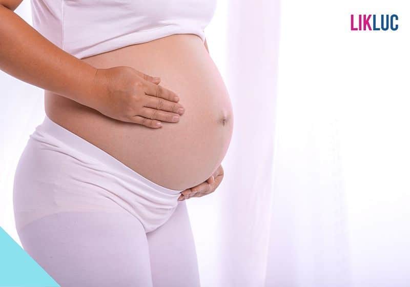 Gestante segurando a barriga fundo branco