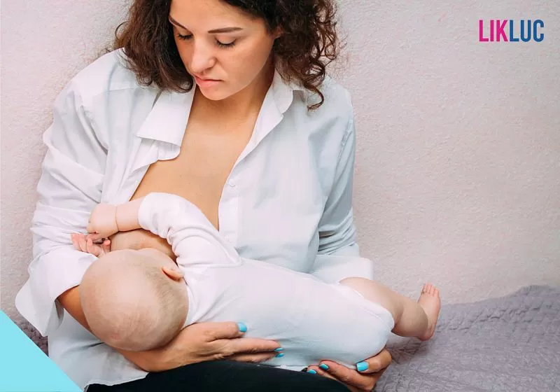 mae amamentando bebe fundo rosa claro