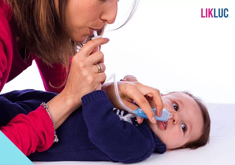 aspirador nasal mae usando aspirador nasal em seu bebe deitado