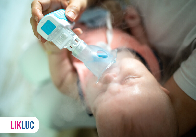 Bebê recebendo nebulização com equipamento médico.