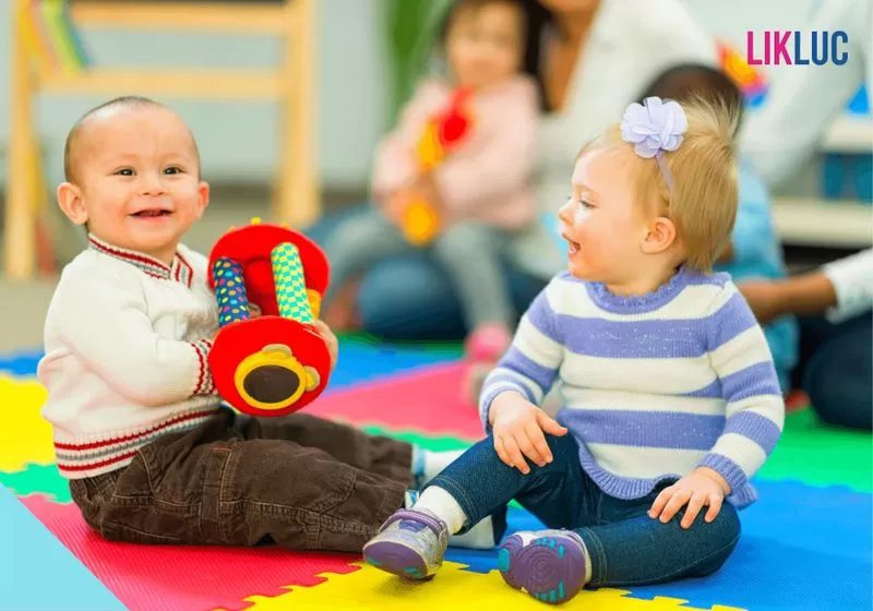 Dois bebês sentados e brincando 