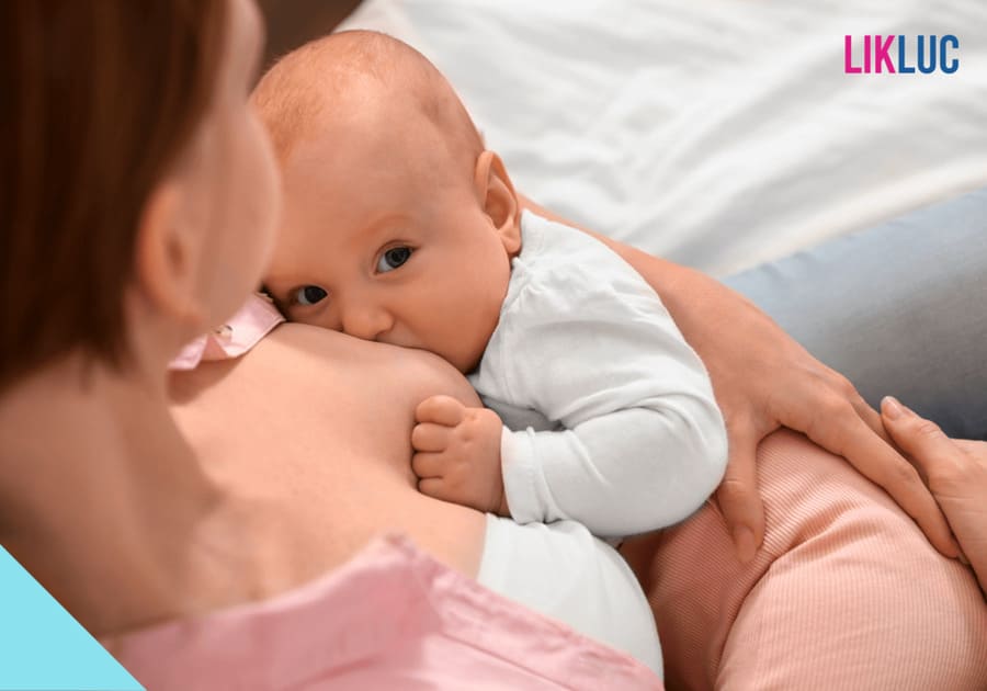 bebe mamando olhando para cima e mae sentada em cima da cama