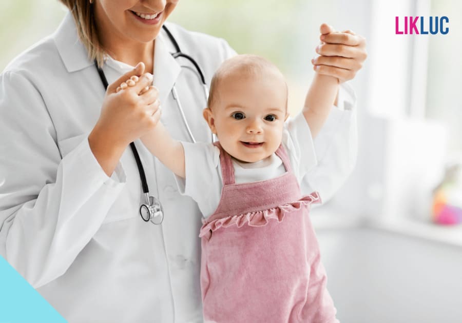 pediatra segurando bebe menina olhando sorrindo para camera