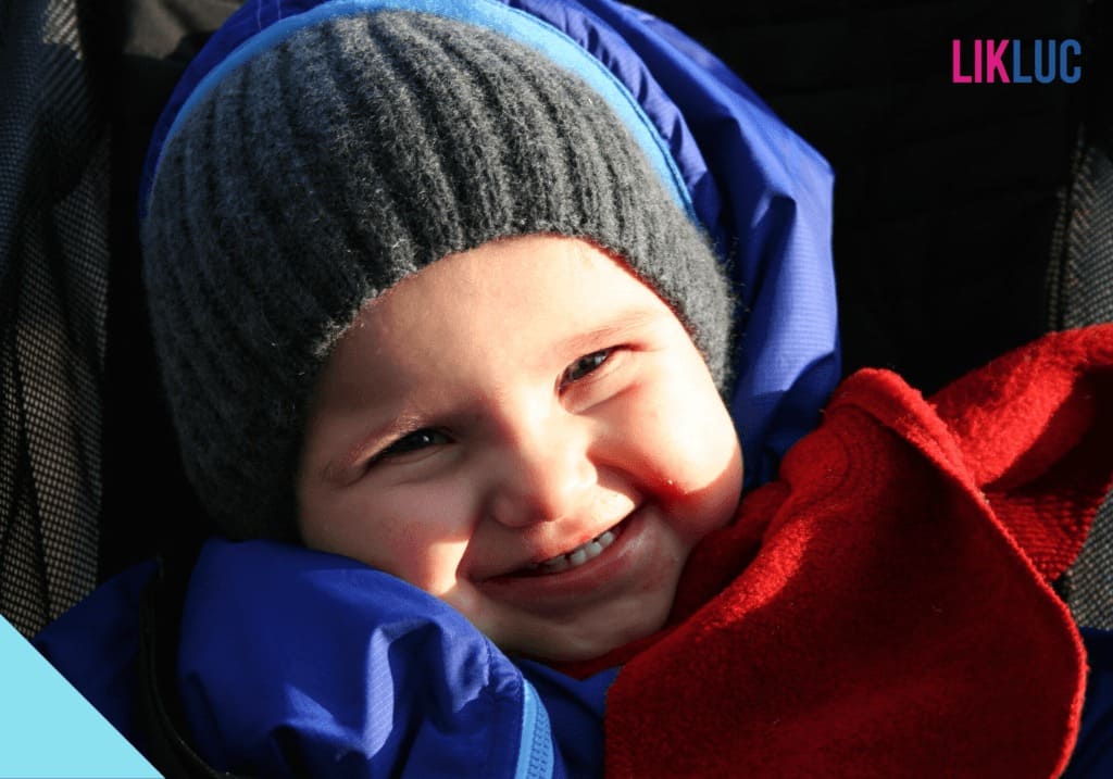 Bebê tomando sol no inverno protegido com roupa de frio