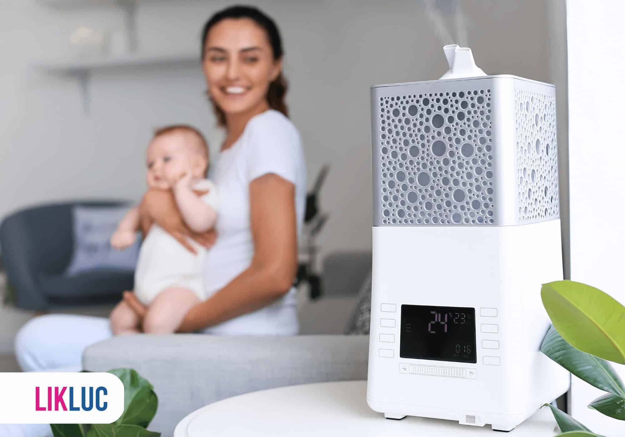 m%C3%A3e com beb%C3%AA olhando para humidificador de ar %281%29 Mãe e seu filho próximos a um umidificador de ambiente