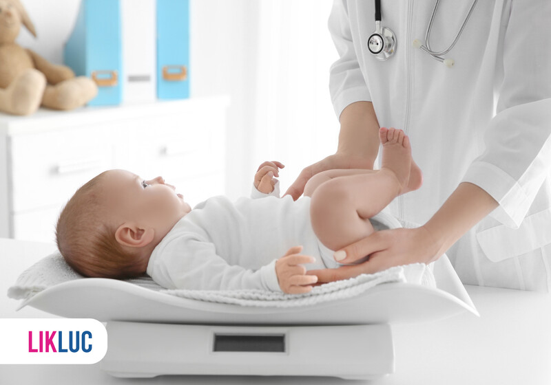 Médico pesando bebê em consulta pediátrica