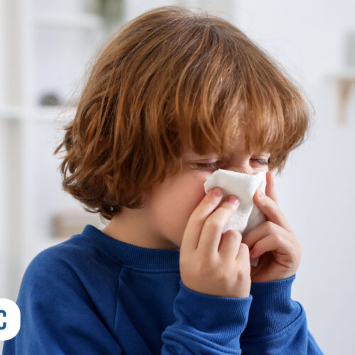 Criança com lenço no rosto, aparentando estar resfriada
