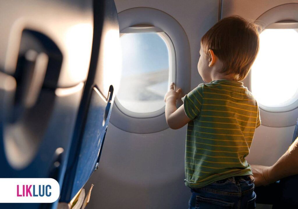 Bebê em pé em um avião olhando pela janela