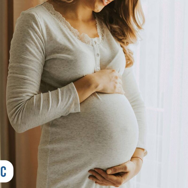 Gestante sorrindo e segurando a barriga pronta para o parto