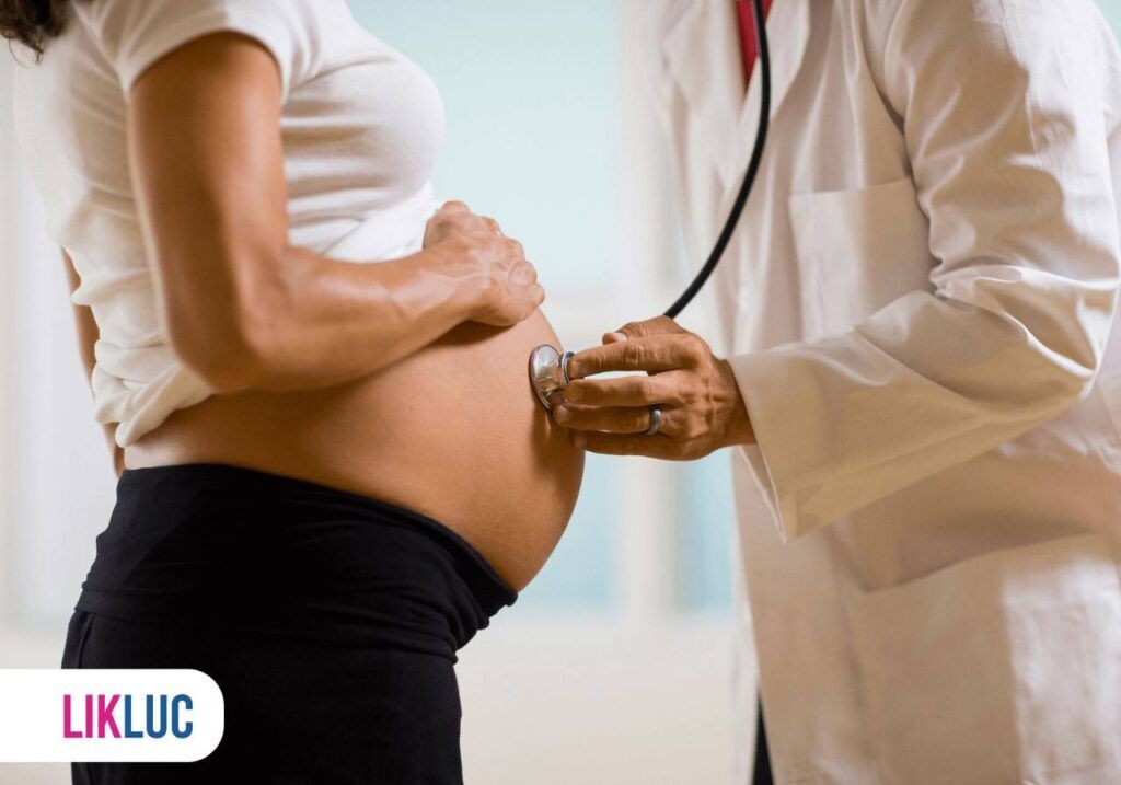 Médico realizando o procedimento de ausculta a barriga da gestante