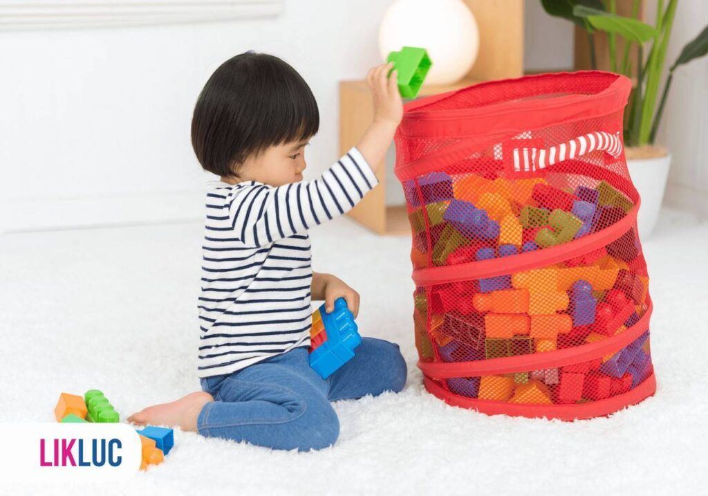 Criança guardando os brinquedos dentro de um saco