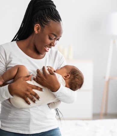 mãe ninando o bebê no colo com uma música