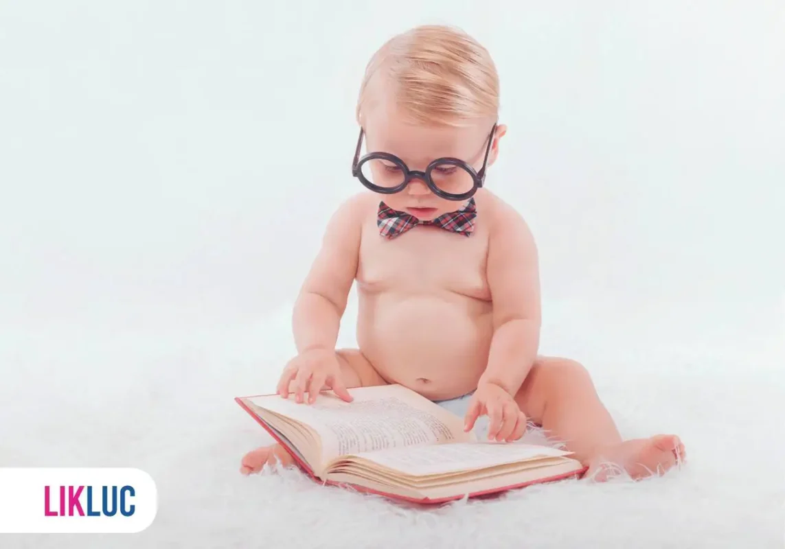 Bebê de óculos e gravata lendo um livro