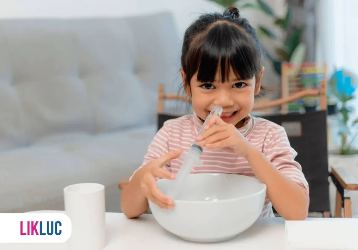 Menina utilizando uma seringa para fazer uma lavagem nasal