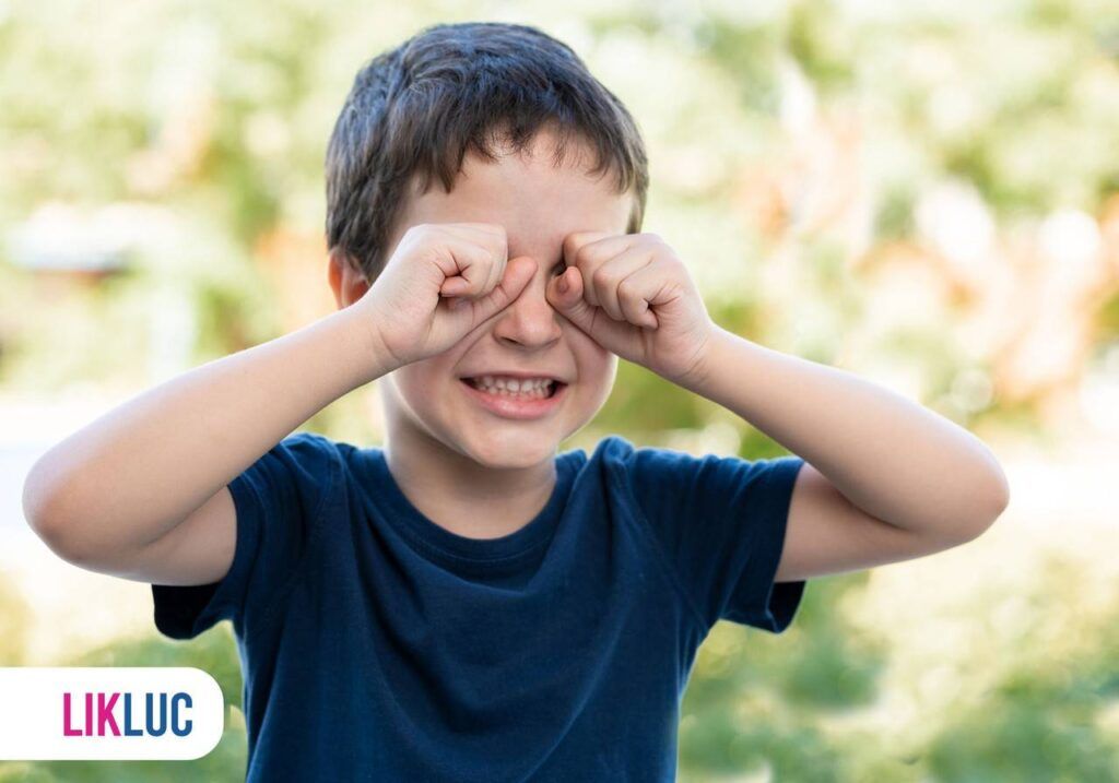 criança com as duas mãos fechadas sobre os olhos