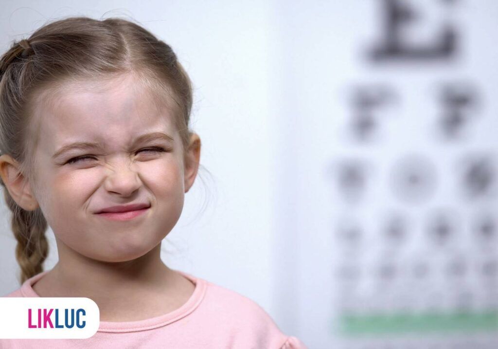 Criança com olhos quase fechados fazendo exame de vista
