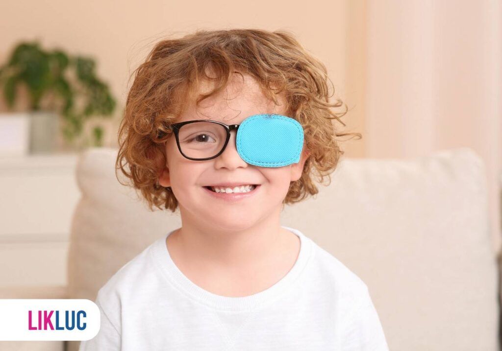 Criança sorrindo, usando óculos com lado esquerdo tampado