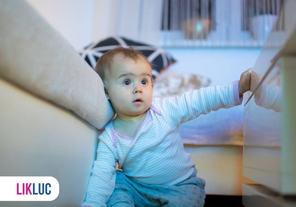 Criança em chão de sala de TV encostada no sofá