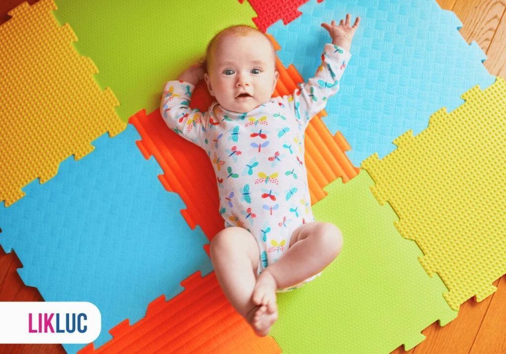 bebê deitado em tapete colorido de brincar