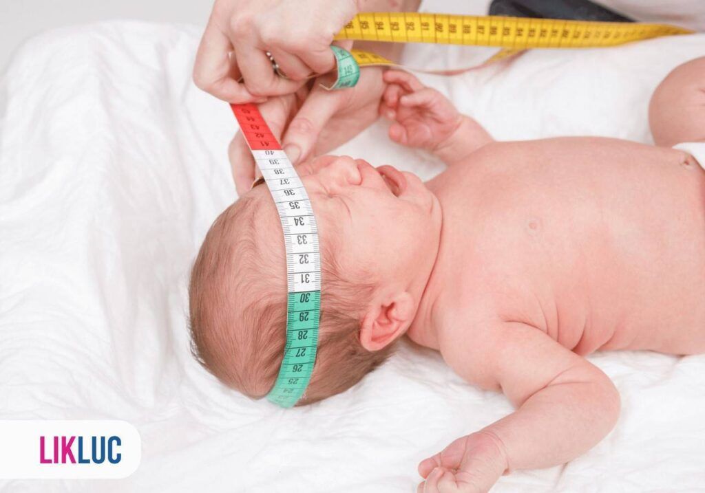 Pessoa medindo com fia métrica a cabeça de bebê