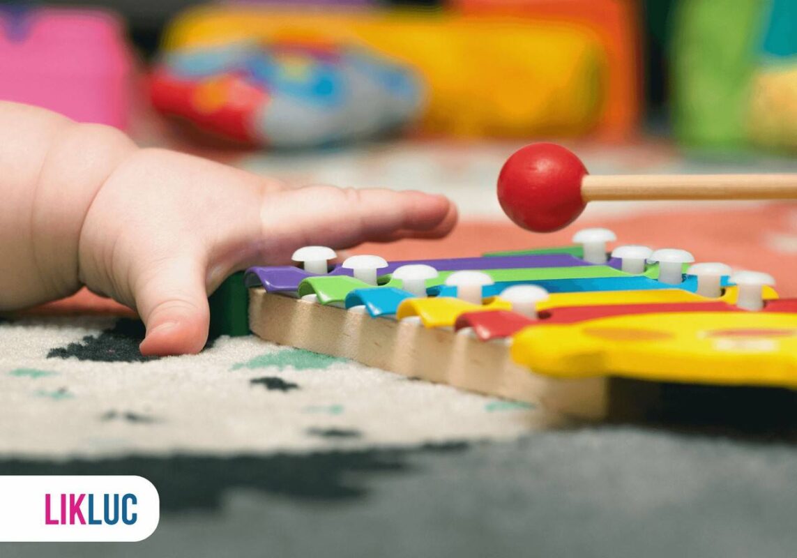 Bebê tocando em brinquedo musical colorido